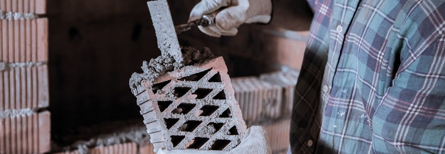 a-mason-applies-cement-to-a-brick-to-build-a-wall-2023-11-27-05-13-18-utc